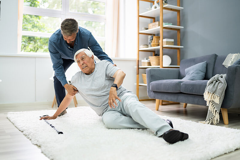 Elderly man receiving help during a fall